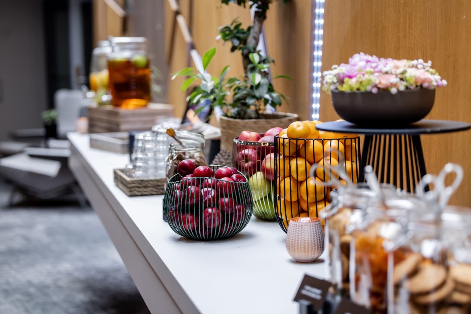 Oppdekket cateringbord med frukt, drikke og blomster